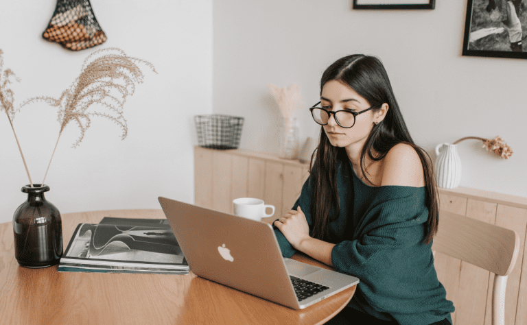 Mulher estudando sobre Google EEAT em casa, usando laptop, ambiente organizado e confortável