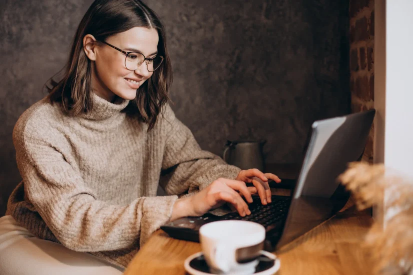 Pessoa trabalhando no computador com um café ao lado procurando as melhores dicas de como contratar um freelancer de SEO.