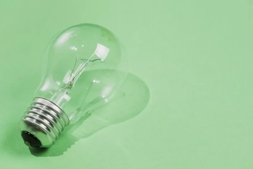 Ilustração de uma lâmpada transparente apagada sobre fundo verde, simbolizando ideias ou inovação de como usar schema markup sem código no WordPress